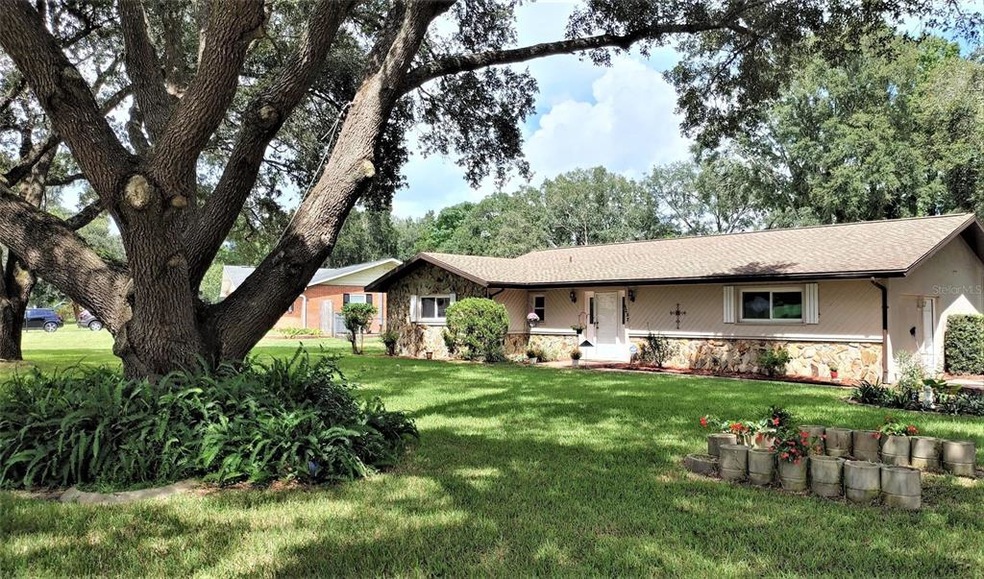 Front of home with beautiful trees.