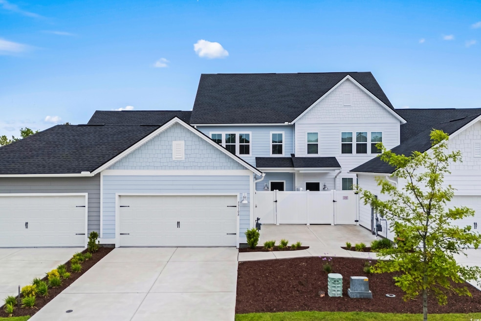 View of front of property featuring a gate, drivew