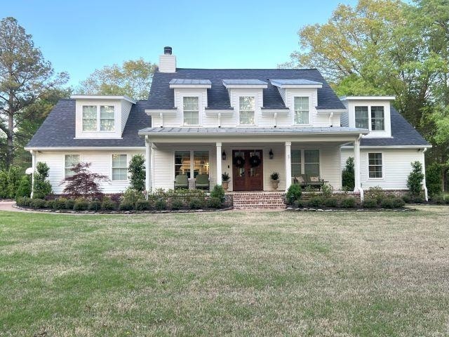 View of front of home with a front yard, a porch, 
