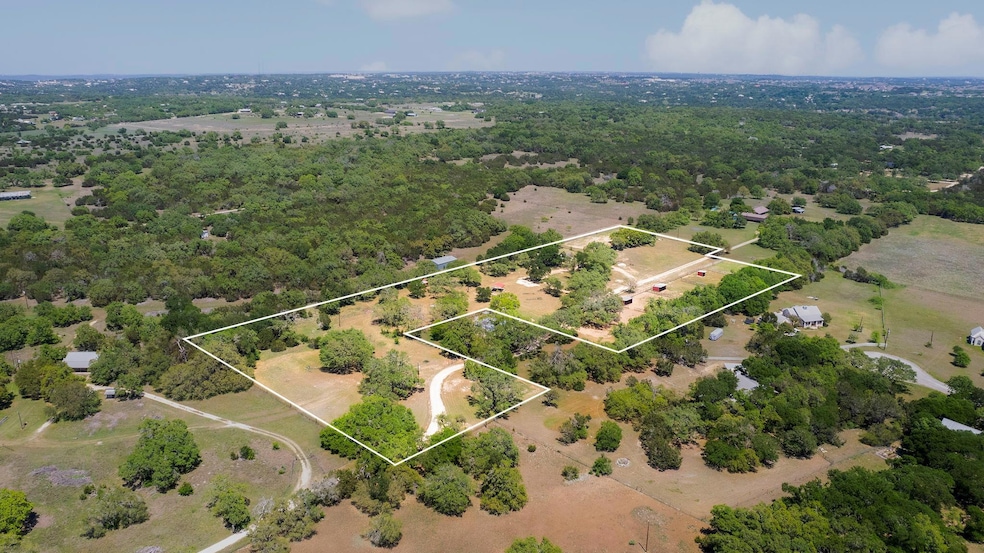 Birds eye view of property with a wooded view