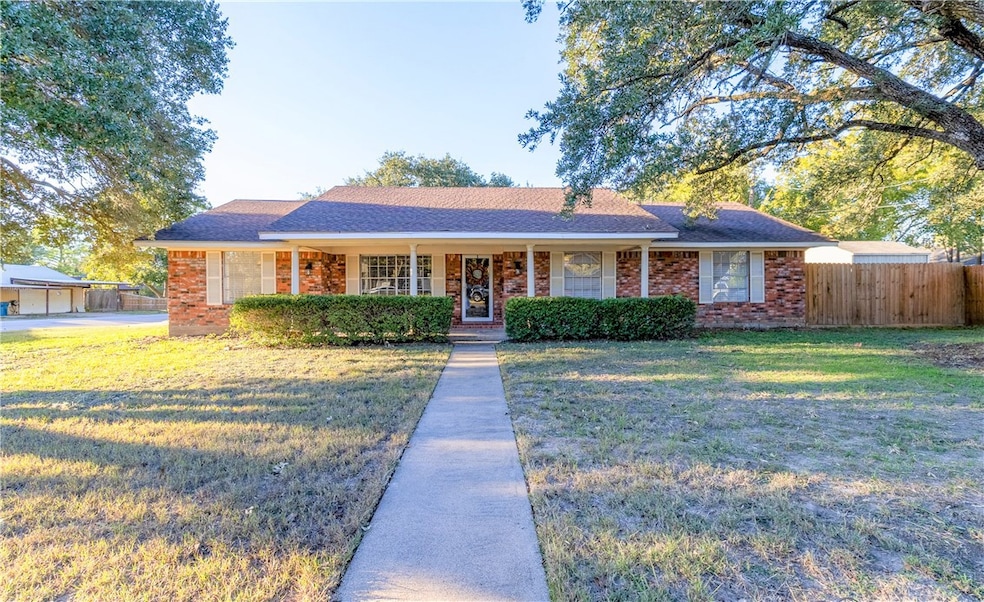 Ranch-style house with covered porch, roof with shingles, and brick siding