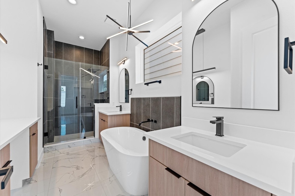 Serene primary bath retreat with designer fixtures