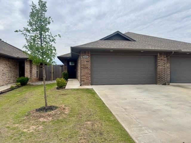 Ranch-style home with driveway, brick siding, an a