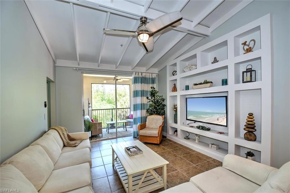Living room featuring ceiling fan, dark tile patte