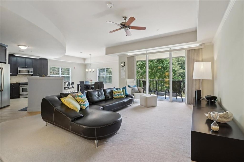 Carpeted living room with ceiling fan