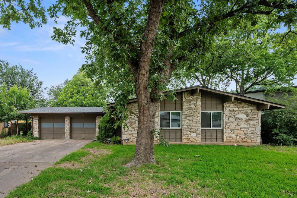 Mid-century modern home featuring stone siding, a