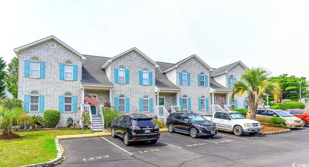 Townhome / multi-family property with uncovered parking and a shingled roof