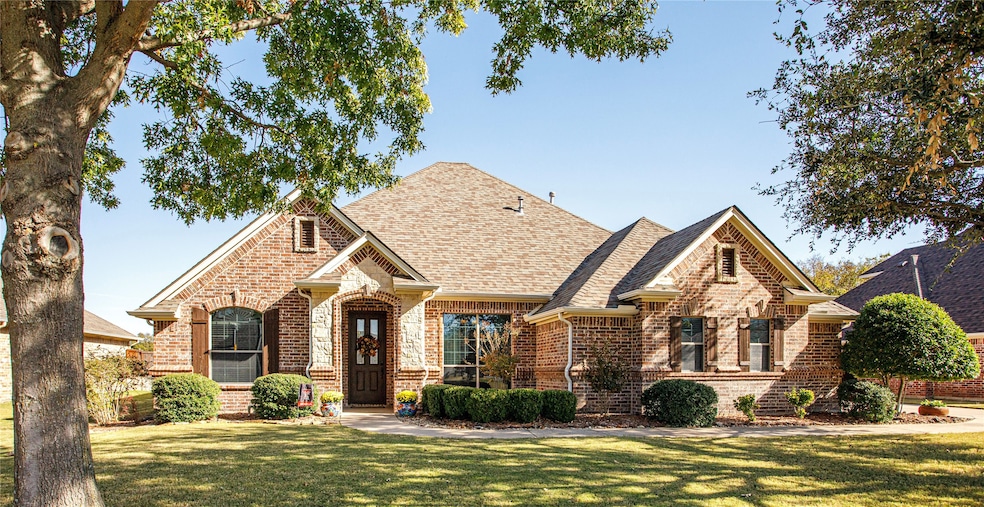 View of front of home with a front lawn, brick siding, and a shingled roof