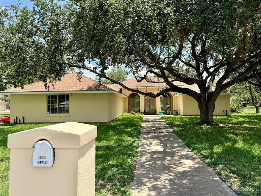 View of front facade with a front lawn and stucco siding
