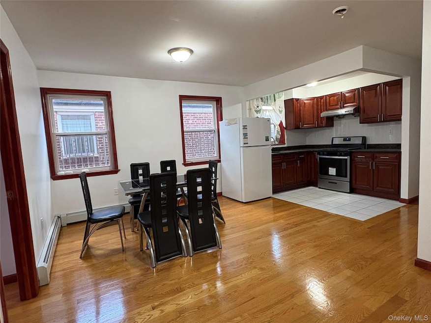 Kitchen featuring dark countertops, stainless steel gas range oven, freestanding refrigerator, and healthy amount of natural light