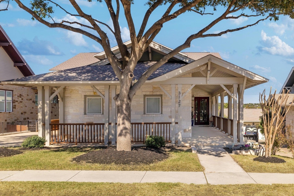 From the street, the home sits slightly elevated, giving you a hint of the bluff that drops to the greenbelt and golf course behind it