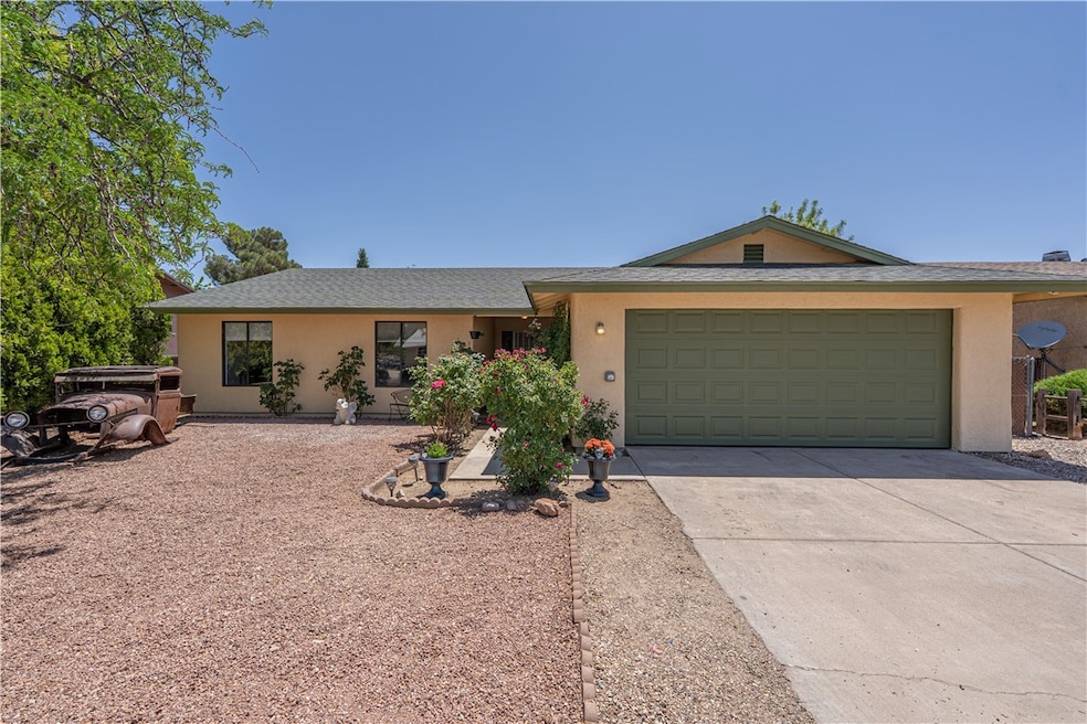 Ranch-style home with driveway, a garage, and stuc