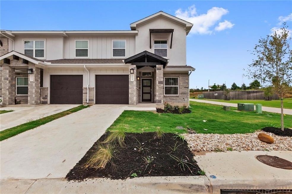View of front of property with stone siding, driv