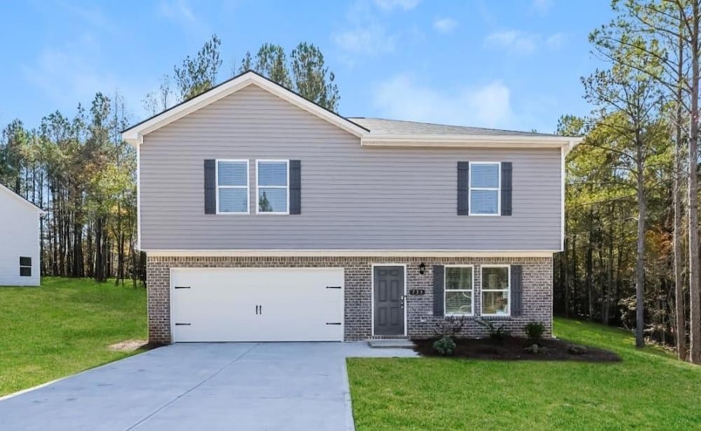 View of front of property featuring a front lawn and a garage