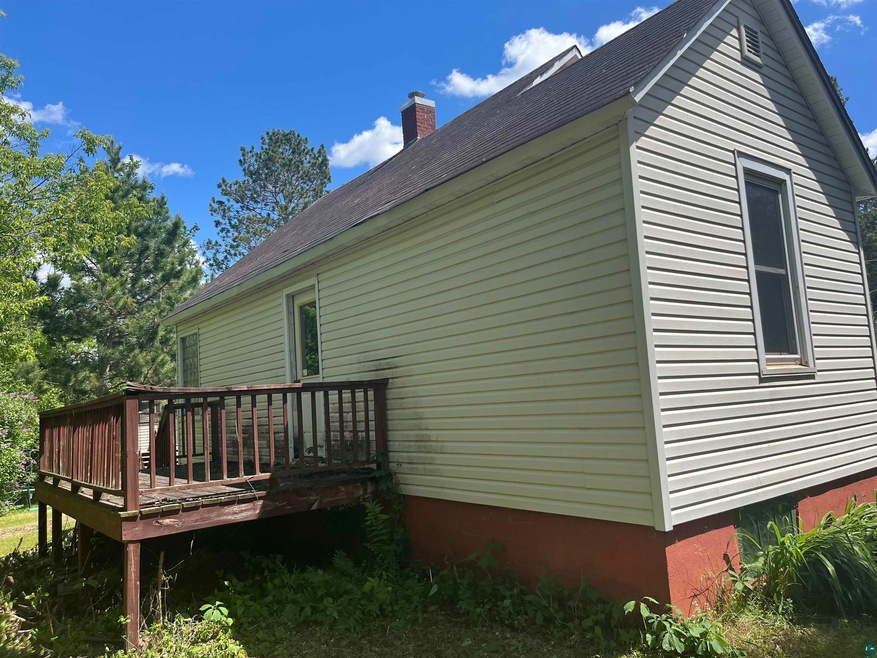 View of side of home featuring a wooden deck