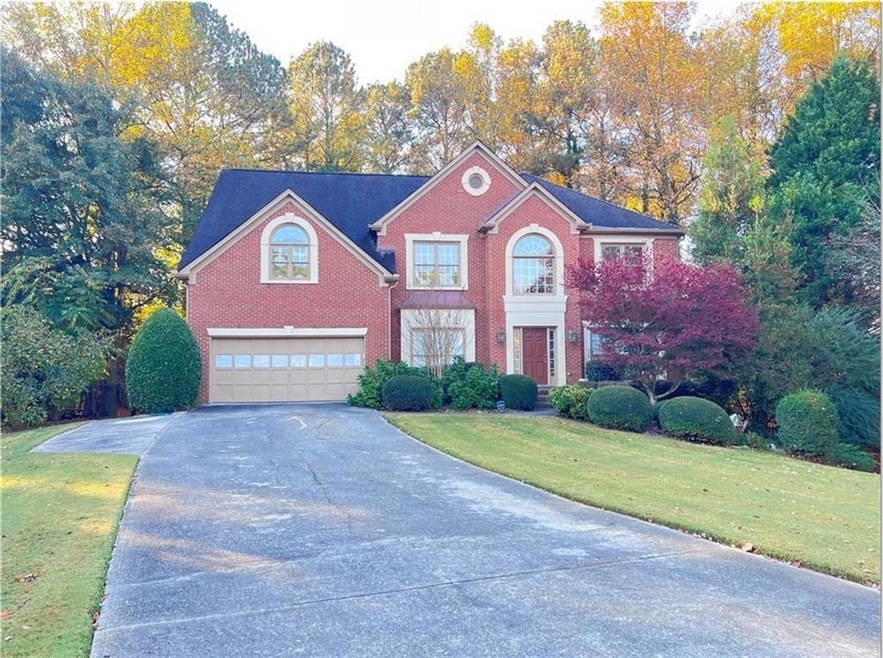 Colonial home with a garage and a front lawn