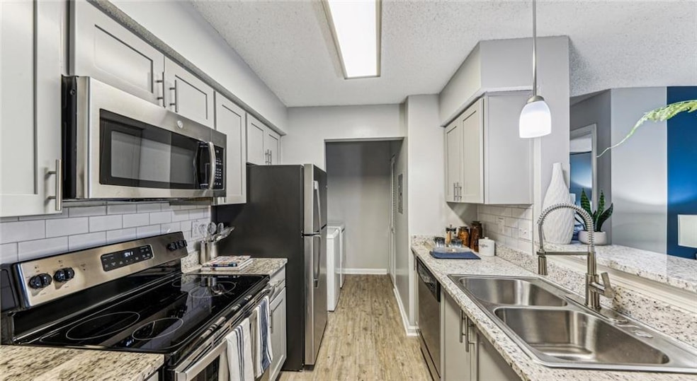 Kitchen featuring light wood-type flooring, applia