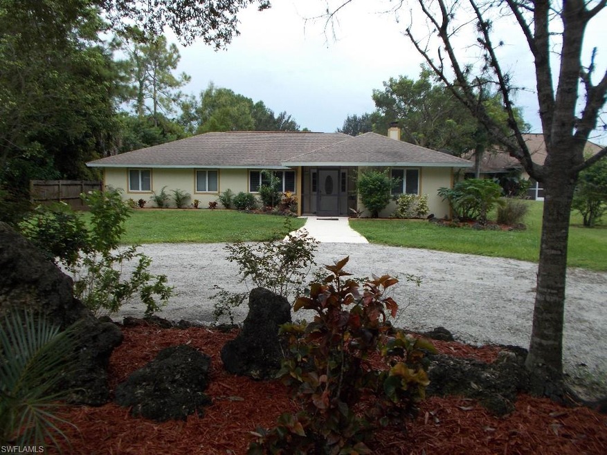 freshly painted home with gravel circle drive and large frontage yard to street