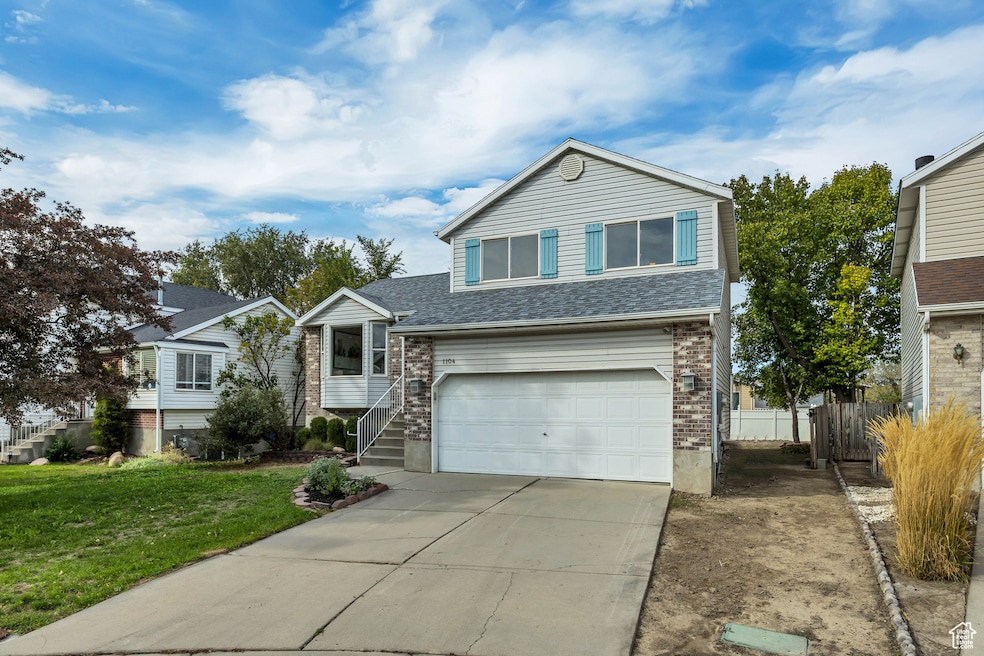 View of front of house featuring a garage, concrete driveway, and brick siding
