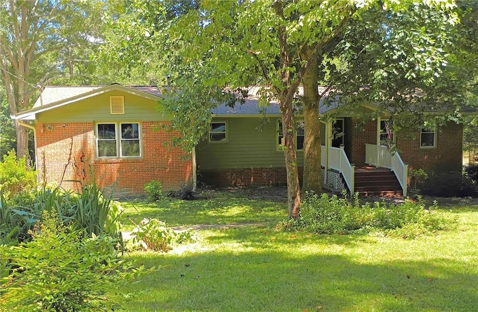 Back of house featuring a yard and brick siding