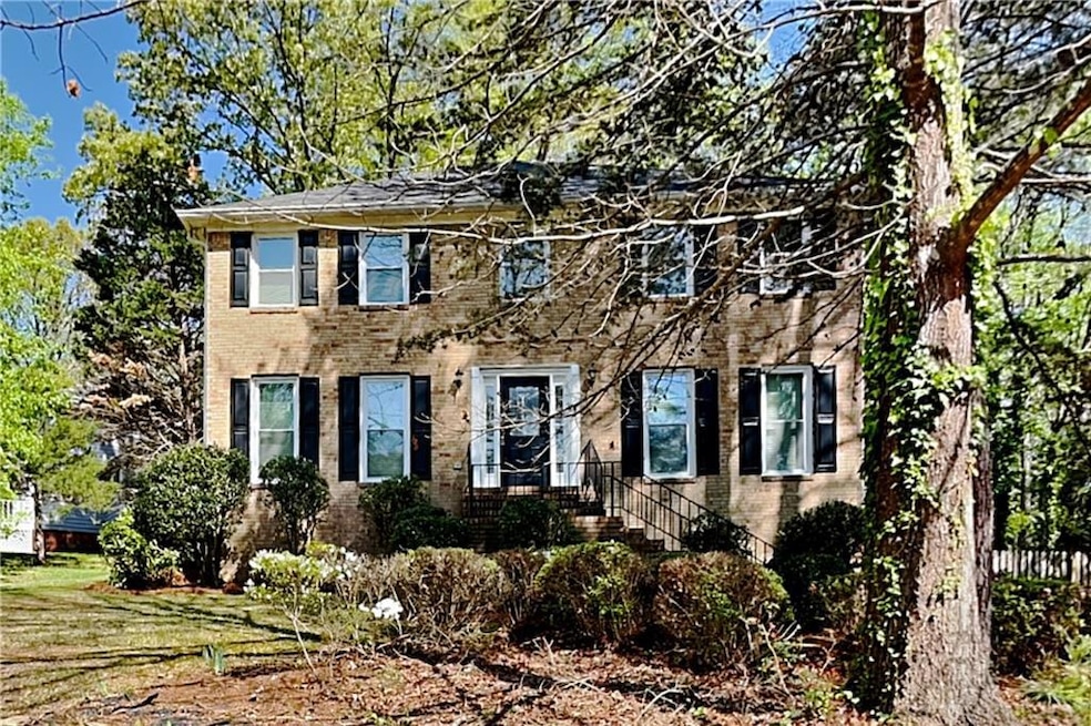 Colonial inspired home featuring a chimney, brick 