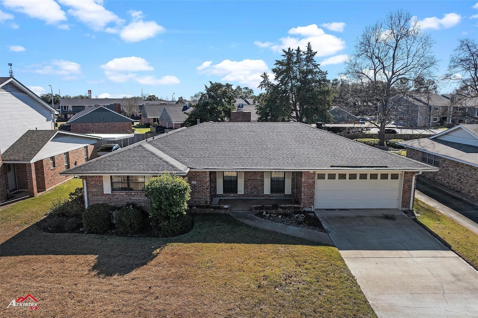 View of front of house with a garage and a front y