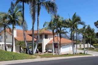 View from the street of the attractive, tile roofed home and its private setting!
