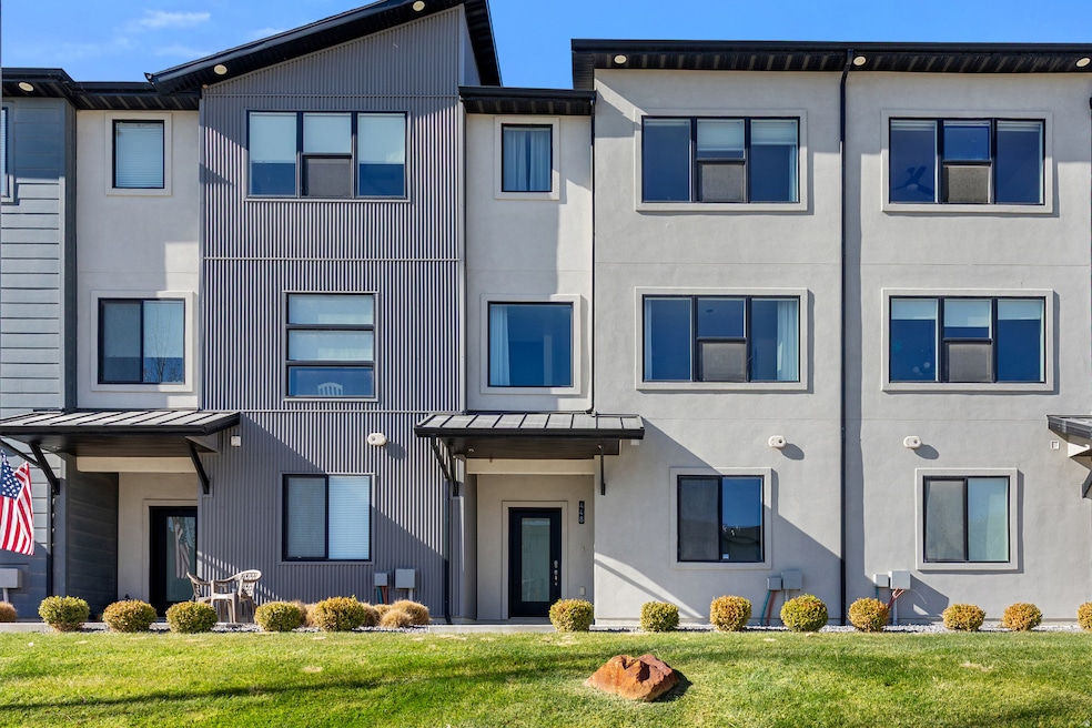 View of front facade with a front yard, stucco siding, a metal roof, and a standing seam roof