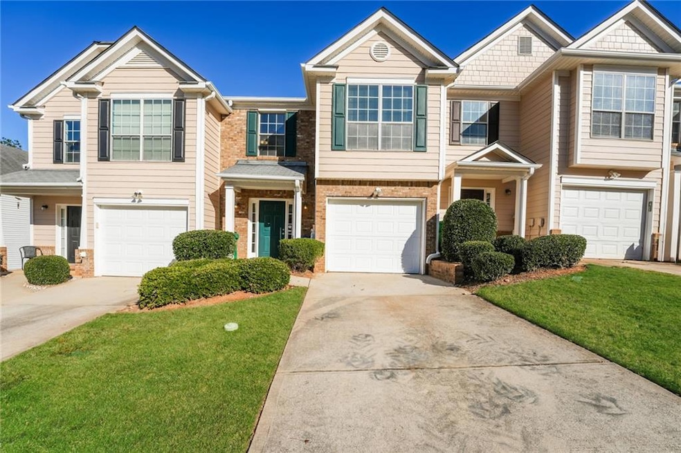 View of front of home featuring concrete driveway, brick siding, and a front yard