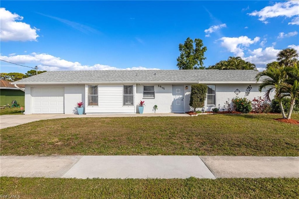 Single story home featuring a garage and a front y