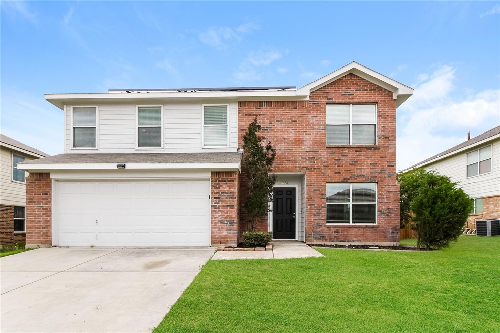 View of property with central AC unit, a front lawn, and a garage