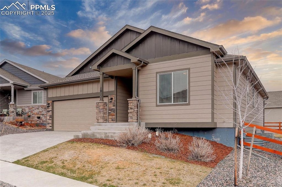 Craftsman-style home with stone siding, board and batten siding, concrete driveway, and a garage