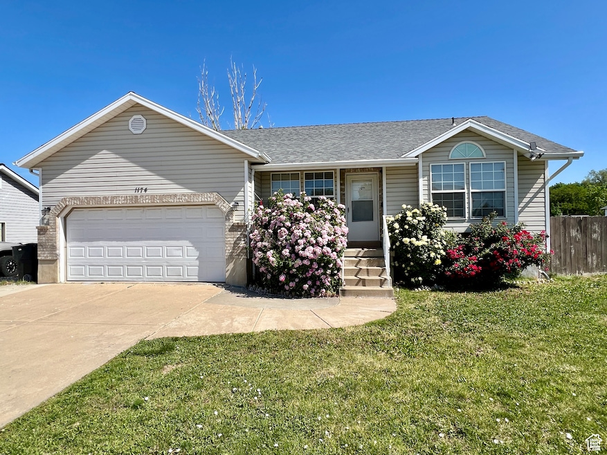 Ranch-style home featuring roof with shingles, driveway, a garage, and a porch