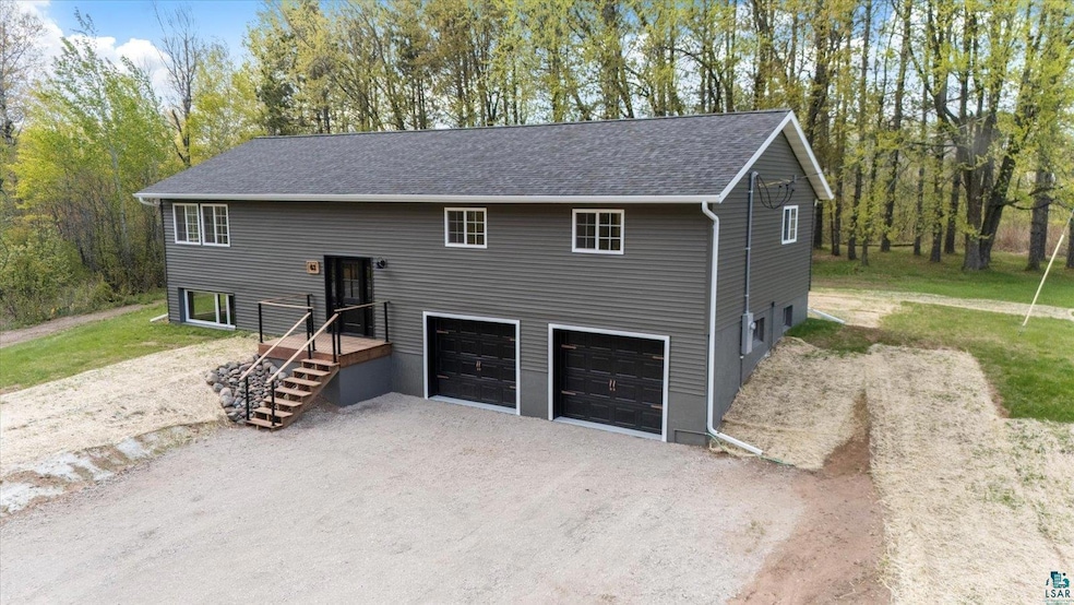 View of front of property featuring driveway, a garage, and roof with shingles