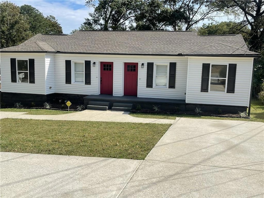 View of front of home with a shingled roof and a front yard