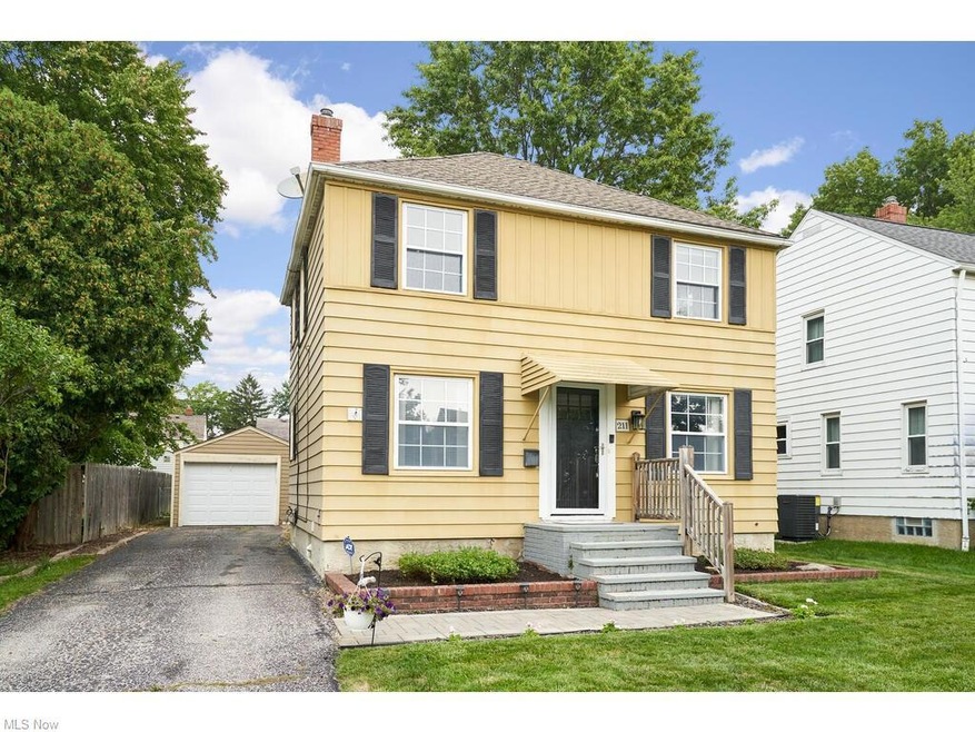 Colonial inspired home featuring a front yard, garage, and central air condition unit
