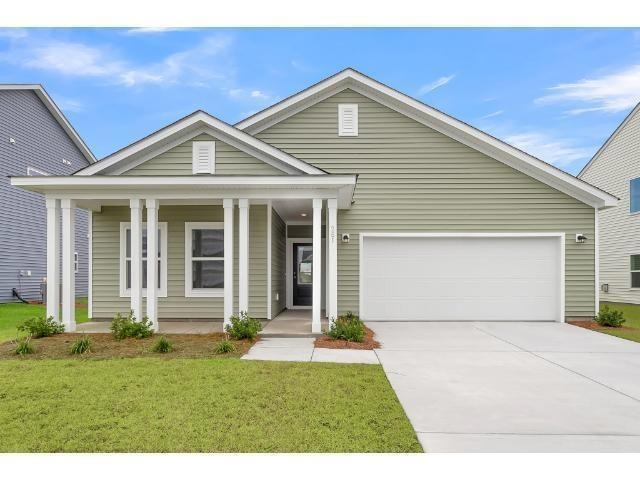 View of front facade featuring a garage, covered p