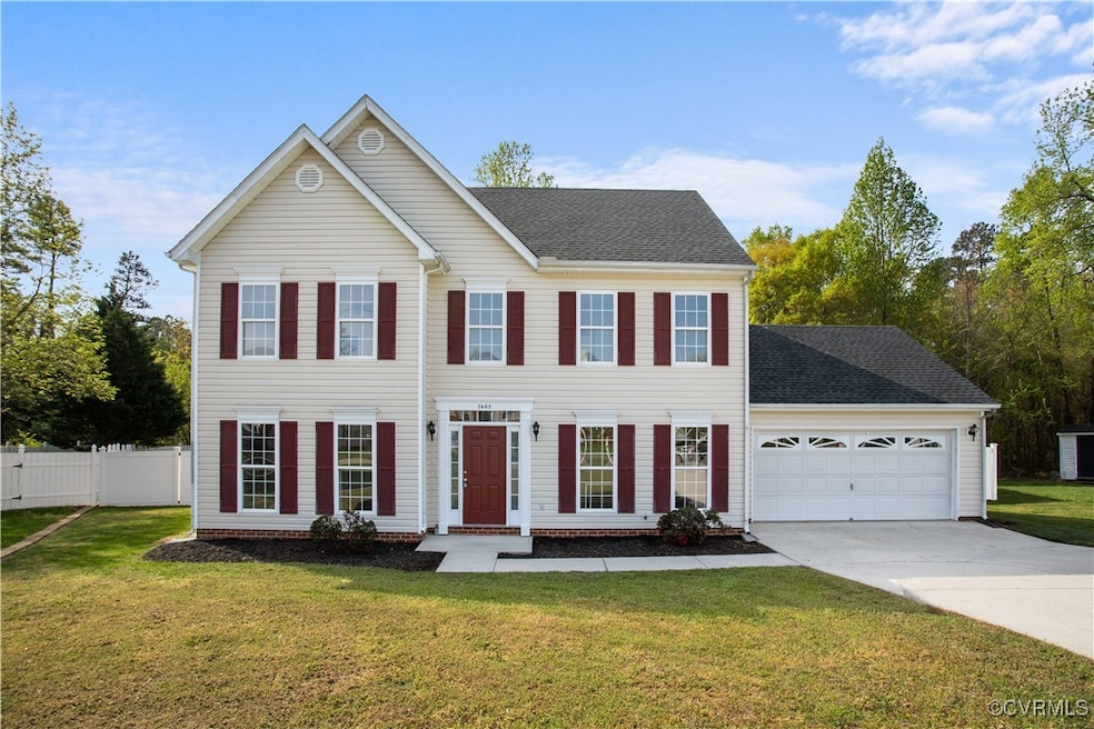 Colonial home featuring driveway, fence, an attach
