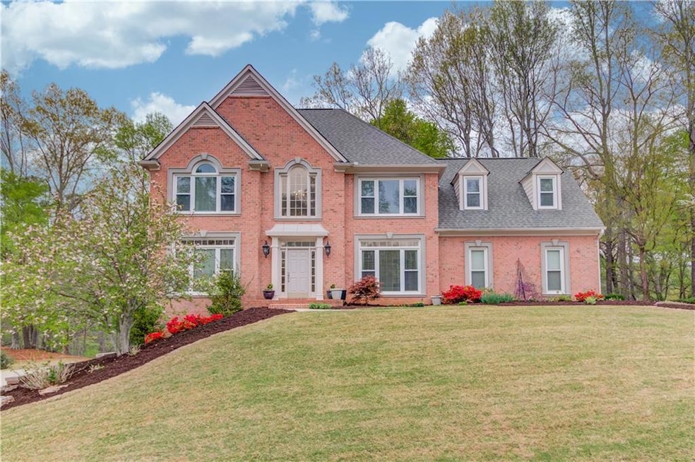 Colonial-style house with brick siding, a shingled