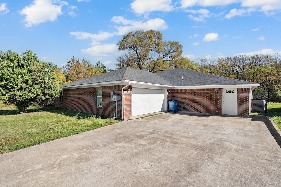 View of home's exterior with brick siding, a yard, concrete driveway, roof with shingles, and a garage