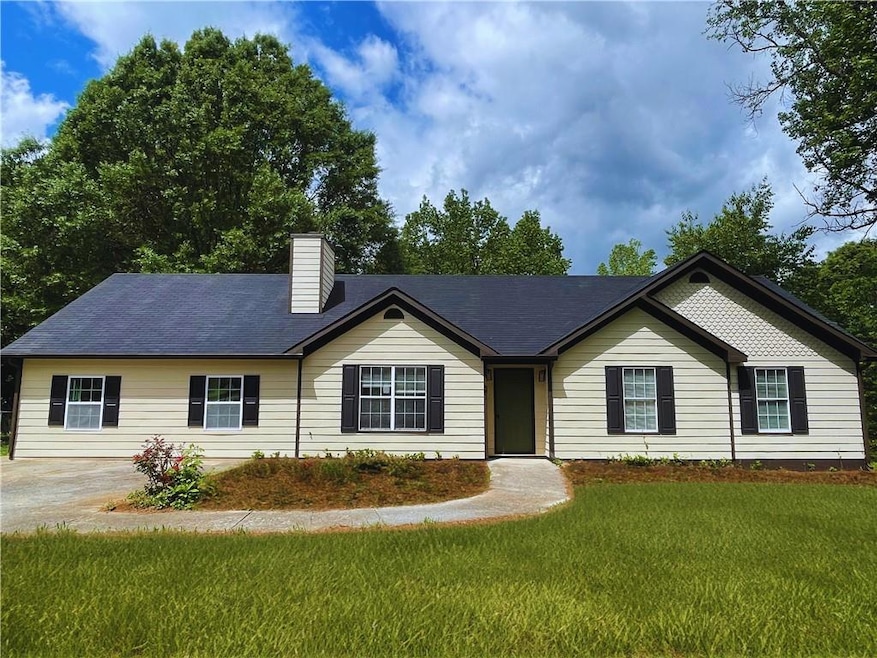 Ranch-style home featuring a chimney and a front y