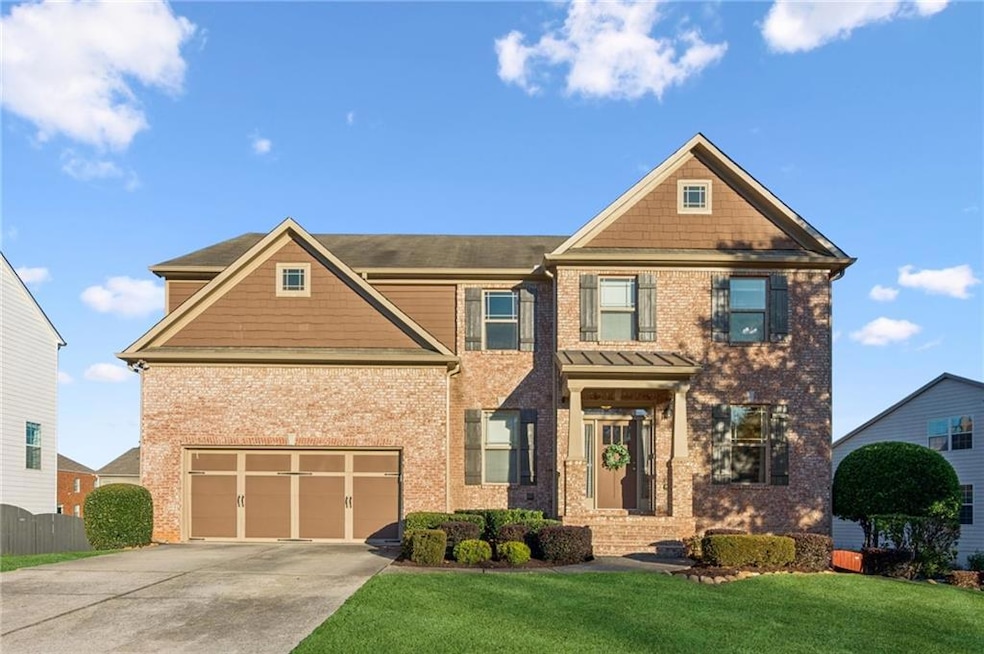 Move-in ready two-story traditional home featuring a welcoming brick front and a spacious two-car garage. Excellent curb appeal with a lush, manicured lawn.