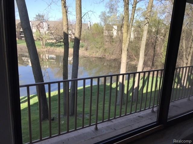 BALCONY OVERLOOKS POND AND WOODED SETTING