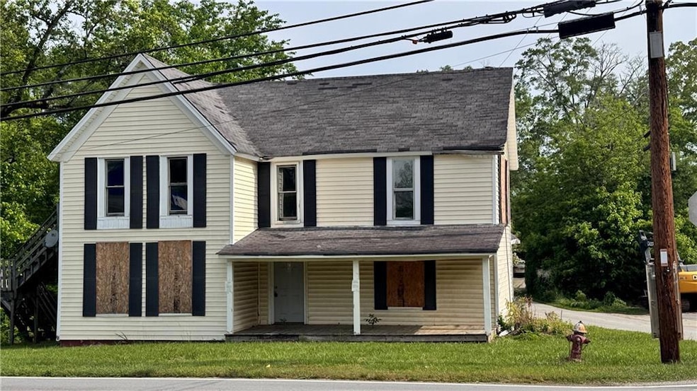 View of front of property featuring roof with shingles, covered porch, and a front yard