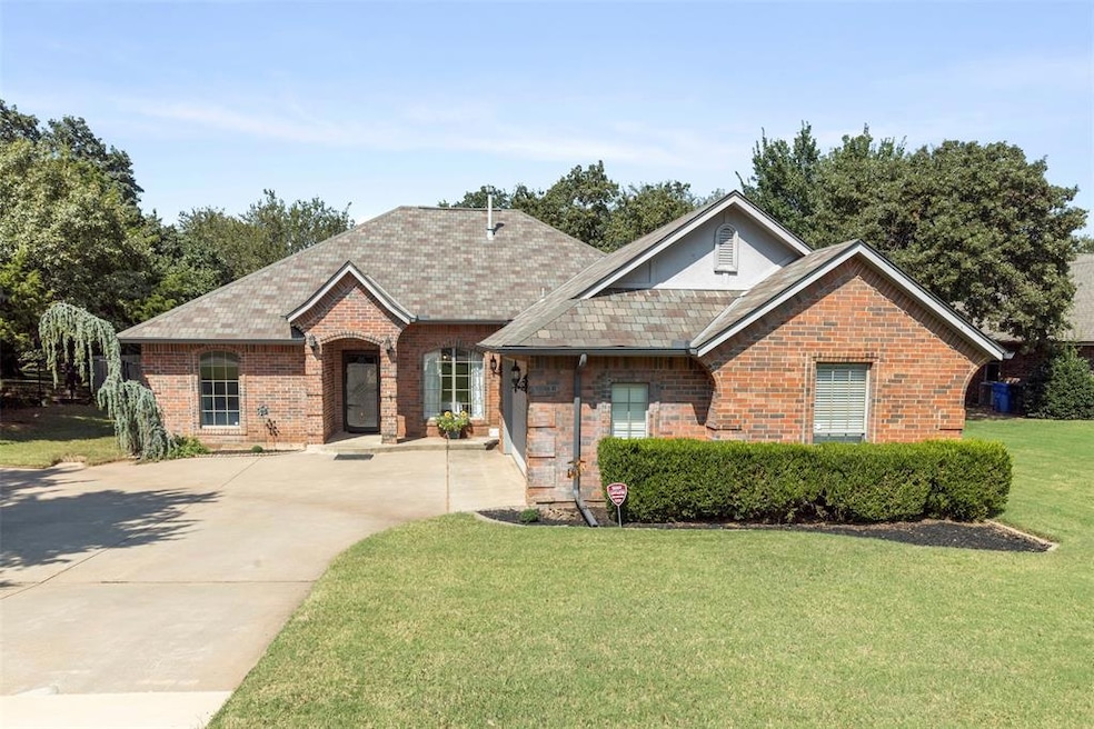 View of front of property with brick siding, a front yard, concrete driveway, and roof with shingles
