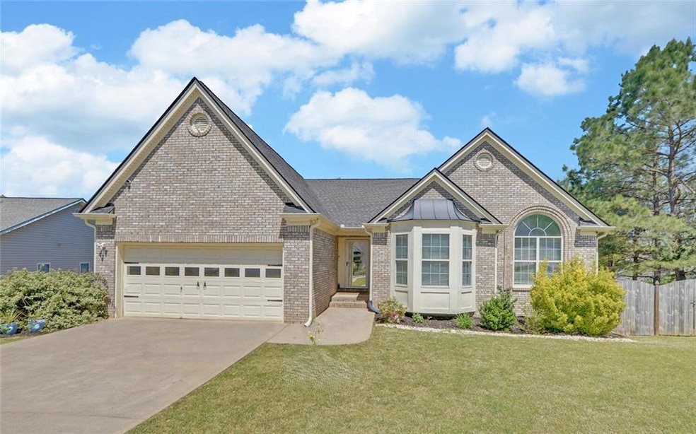 View of front of property featuring brick siding, driveway, and a garage