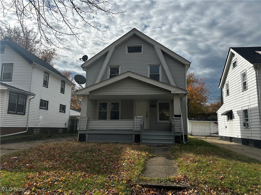 Dutch colonial featuring covered porch, a gambrel roof, and a front lawn