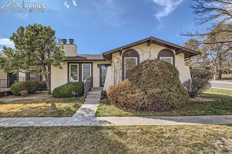 View of front of house with stucco siding, a chimn