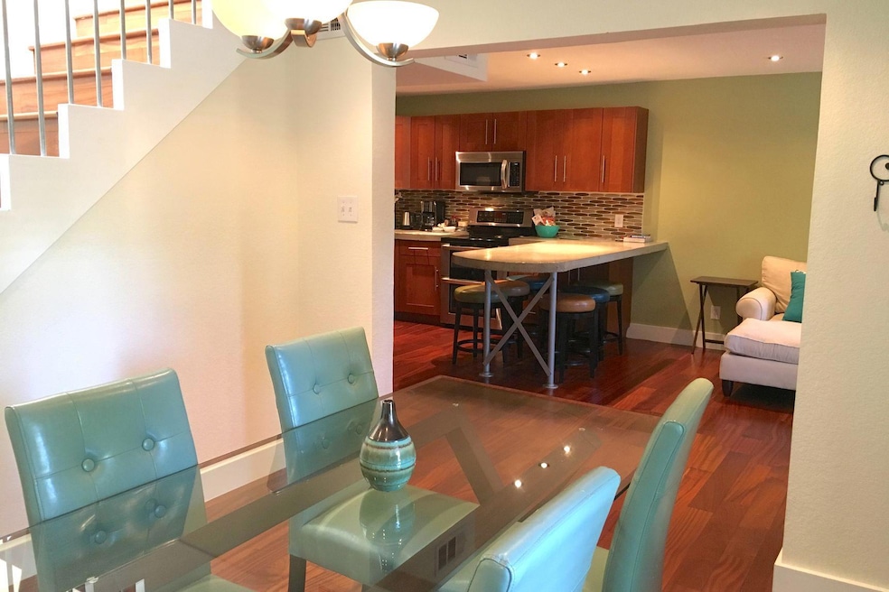 Dining room with dark wood-style flooring, basebo