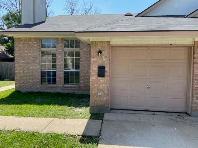 View of front of property with brick siding, a ga